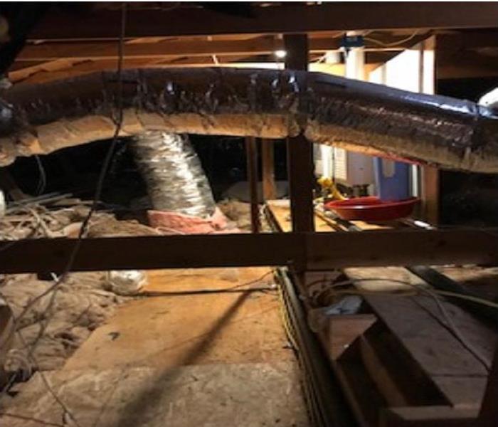 Attic with water filtration system with the hvac system and insulation for the home on plywood flooring.  