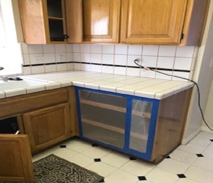 Kitchen of the tile countertop, upper cabinet and lower cabinet is covered with containment