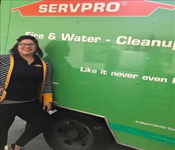 Alyssia smiling from ear to ear, standing in front of the SERVPRO truck for her photo op.