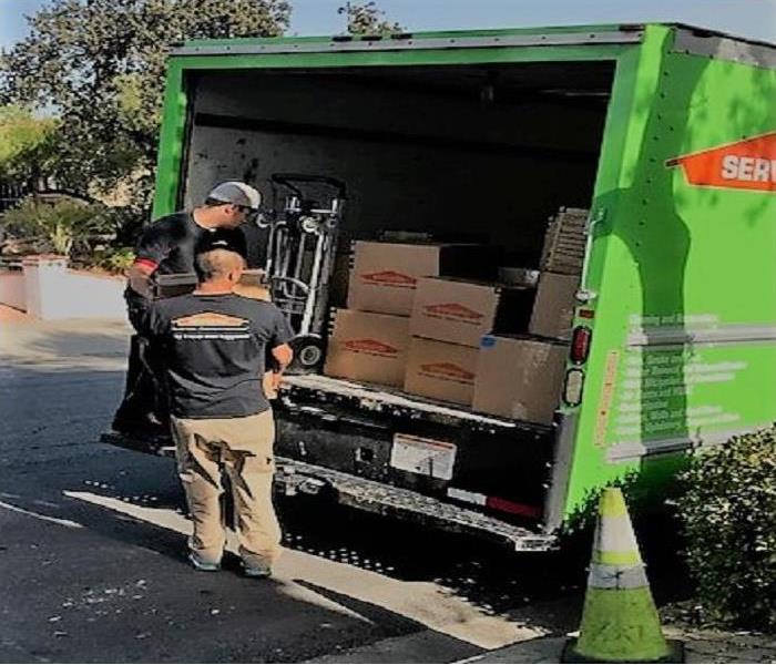 Crew members helping each other load boxes