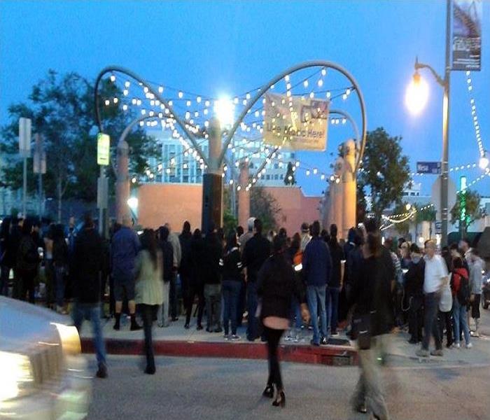 Crowded corner street with a large gathering entering the street art fair.